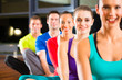 Photo: Group of people and instructor in gym stretching Group of people and instructor in gym stretching