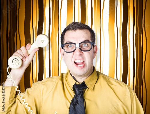 Photo: Frustrated male office worker yelling with phone Frustrated male office worker yelling with phone