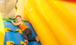 Young boy playing in an inflatable slide