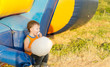 Young boy eating cotton-candy sitting near a slide