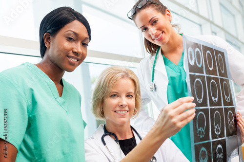 Photo: Female doctor and nurses look at CT scan Female doctor and nurses look at CT scan
