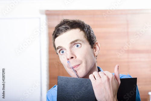 Photo: Thinking business man with diary and pen Thinking business man with diary and pen