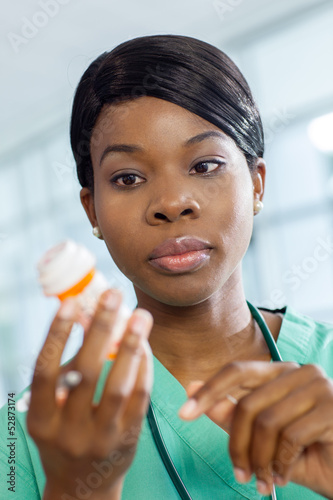 Photo: Nurse examines prescription bottle Nurse examines prescription bottle