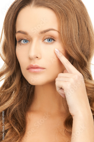 Photo: woman pointing at her eye area woman pointing at her eye area