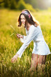Photo: Vintage looking pose of a Young woman standing in a wheat field Vintage looking pose of a Young woman standing in a wheat field