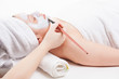 Beautiful woman having facial mask applied