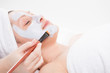 Portrait of a woman applying facial mask