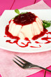 Panna Cotta with raspberry sauce, on color wooden background