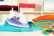 Clothes and iron on table on shelves background