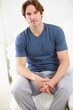 Man Sitting On Bed Wearing Pajamas