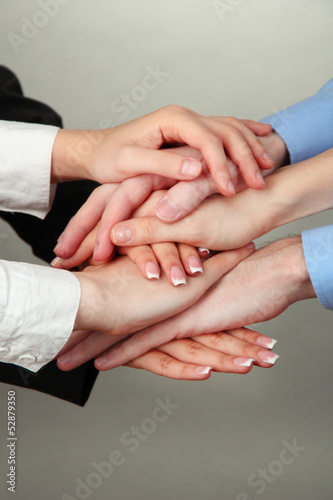Photo: Group of young people's hands on gray background Group of young people's hands on gray background