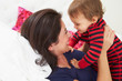 Mother And Toddler Lying In Bed Together
