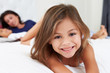 Mother And Children Relaxing In Bed Wearing Pajamas
