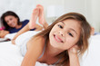 Mother And Children Relaxing In Bed Wearing Pajamas