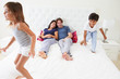 Children Jumping On Parents Bed Wearing Pajamas