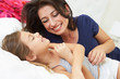 Mother And Daughter Lying In Bed Together
