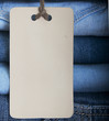 Pile of blue jeans with tag label.