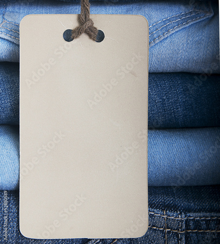 Photo: Pile of blue jeans with tag label. Pile of blue jeans with tag label.