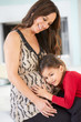 Foto: Daughter Listening To Pregnant Mother's Stomach Daughter Listening To Pregnant Mother's Stomach