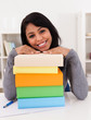 Young Woman Smiling On Stack Of Books