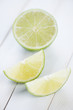 Sliced ripe lime on wooden boards, vertical shot