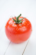Ripe tomato covered with water drops, vertical shot