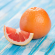 Close-up of ripe grapefruit and its segment on wooden boards