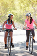 Photo: Two Women Cycling On Suburban Street Two Women Cycling On Suburban Street