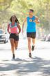 Photo: Woman Running Along Street With Personal Trainer Woman Running Along Street With Personal Trainer