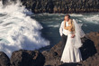 Bride and groom embracing standing at the waterfall.