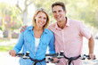 Couple Cycling On Suburban Street