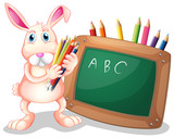 A bunny with coloring pens beside a blackboard