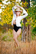 sexy portrait woman with hat and white shirt in the autumn park