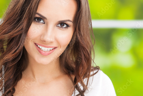 Photo: Happy smiling young woman, outdoors Happy smiling young woman, outdoors