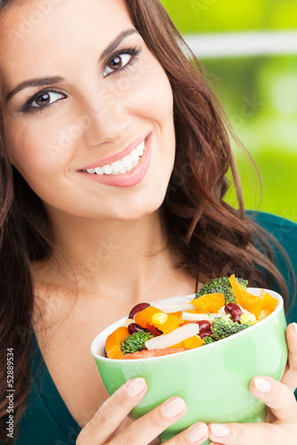 Photo: Young woman with salad, outdoors Young woman with salad, outdoors