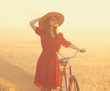 Girl on a bike in the countryside in sunrise time.