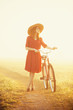 Girl on a bike in the countryside in sunrise time.