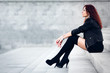 Beauty girl sits on a concrete steps