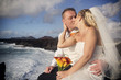 Bride and groom kissing at the ocean shore.