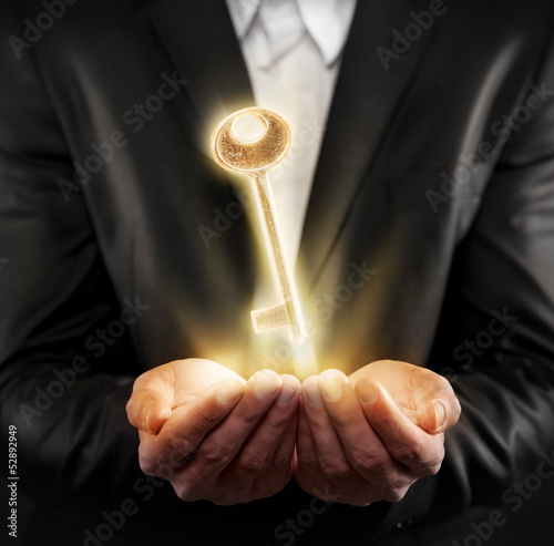 Photo: Male hands holding a golden key Male hands holding a golden key