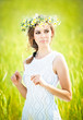 Portrait of beautiful blonde girl with wreath of wild flowers.