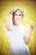 Portrait of beautiful blonde girl with wreath of wild flowers.