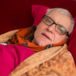 60 years old man with glasses lies sick in bed