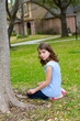 beautiful kid girl smiling sitting on park lawn relaxed