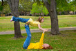 Daughter and mother playing keep balance lying on park
