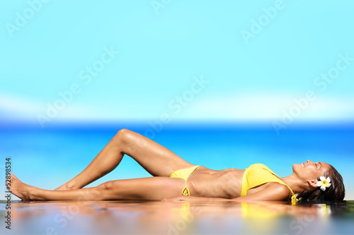Photo: Sunbathing woman relaxing under sun in luxury Sunbathing woman relaxing under sun in luxury