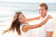 Happy couple on beach in love having fun