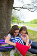 sister firends girls relaxed under tree park after school