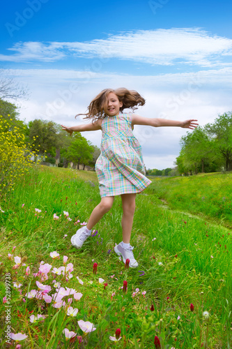 Photo: happy children girl jumping on spring poppy flowers happy children girl jumping on spring poppy flowers