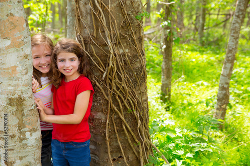 Photo: children friends playing in tree trunks at the jungle park children friends playing in tree trunks at the jungle park